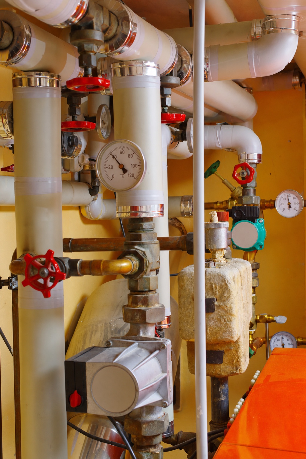 Unbranded mechanical room piping, pumps and temperature gauges